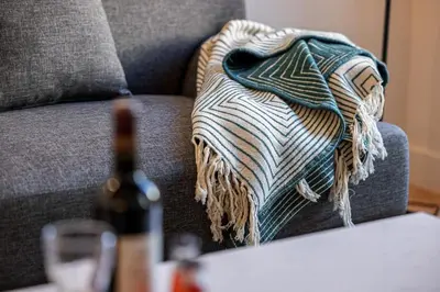 a blanket sitting on a couch next to a bottle of wine at MY CASA - PHILIBERT - Traditional Apart with Historical Fresc in Nice
