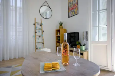 a table with a bottle of wine and two glasses at Maison Bianchi - Lamartine in Nice