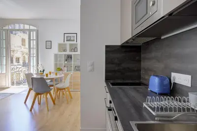 a kitchen with a sink and a table with chairs at Maison Bianchi - Lamartine in Nice
