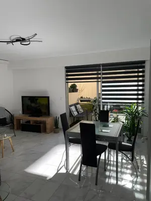 a dining room with a table and chairs and a television at Superbe appartement carré Delfino Port de Nice in Nice