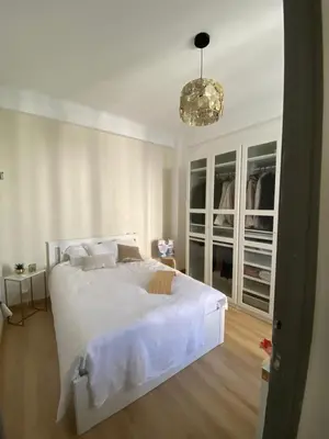 a white bedroom with a white bed and a chandelier at Nice - Appartement T3 rénové de 50 M2 classé 2 étoiles in Nice